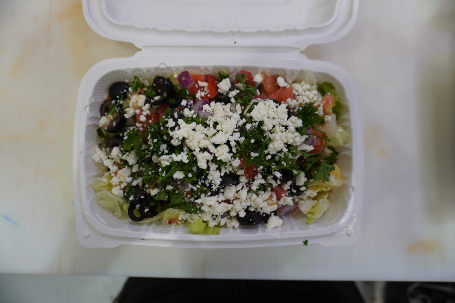 A Greek salad packed with feta, olives, tomato and parsley